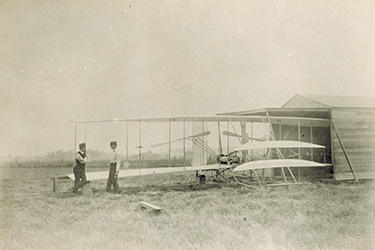 photo of the wright brothers with a plane partially in a hangar