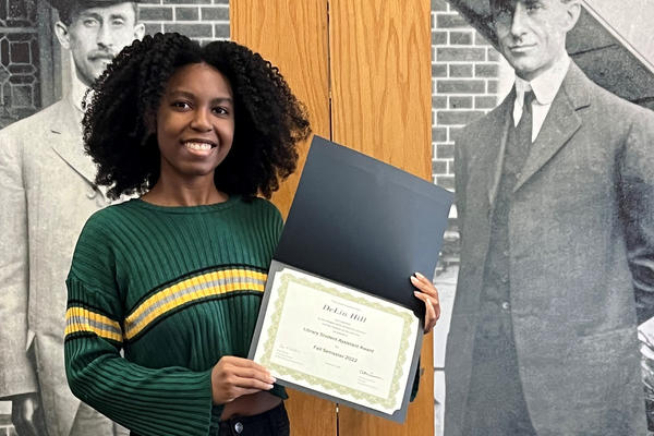 student holding library student assistant award