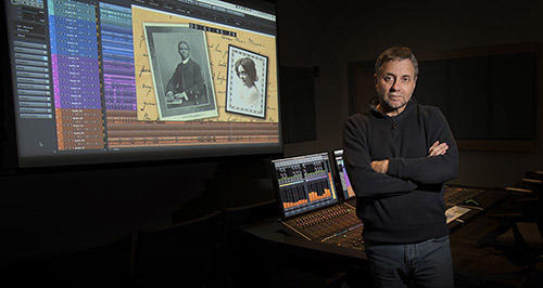 Speaker standing by screen showing film Dunbar Beyond the Mask