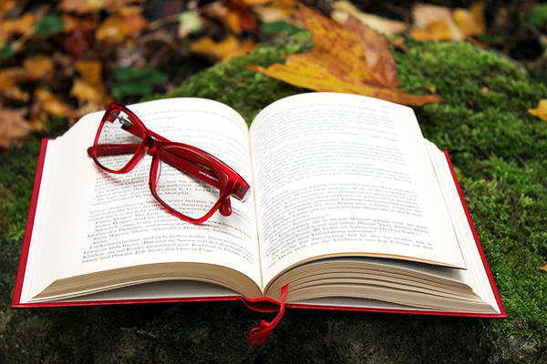 Image of open book with eyeglasses on top