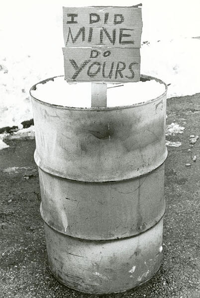 A sign in a barrel on a shoveled sidewalk that reads "I Did Mine Do Yours"