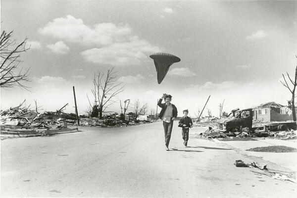 Aftermath of the Xenia tornado showing two boys running down the middle of a tornado ravaged street. One boy is holding a kite.