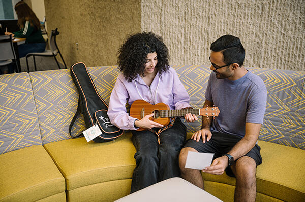 Students playing a ukulele from the Library of Things collection