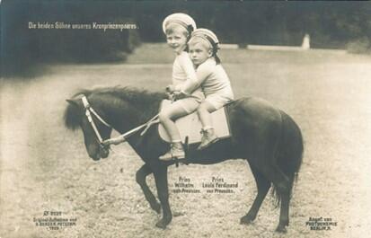 Two young boys in hats riding a miniature pony.