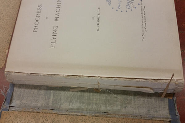 Progress in Flying Machines book by Chanute open showing detached textblock prior to treatment