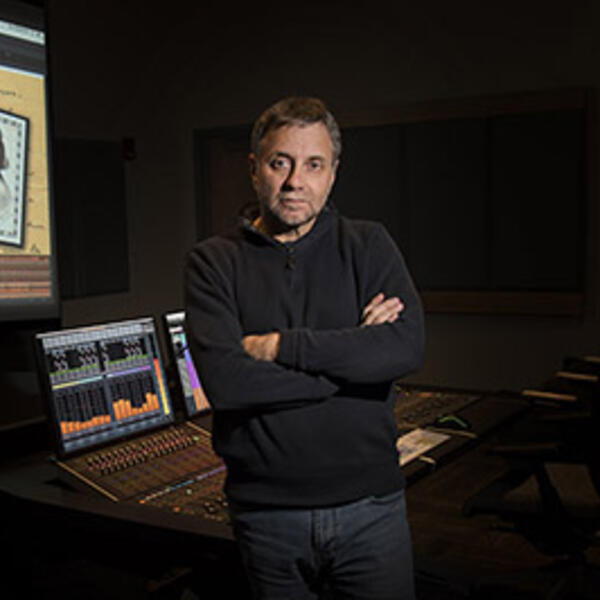 Speaker standing by screen showing film Dunbar Beyond the Mask