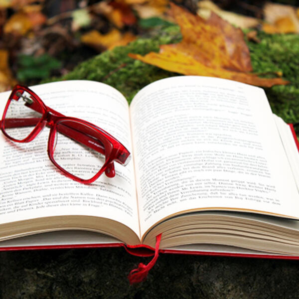 Image of open book with eyeglasses on top