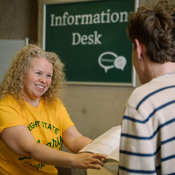 Image of Maggie Perry assisting a student at the Information Desk