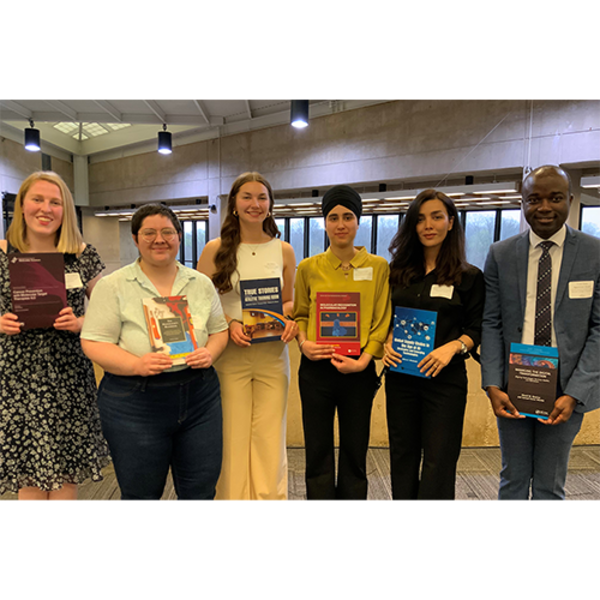 Image of 2026 Graduate Student Award recipients holding their selected library books