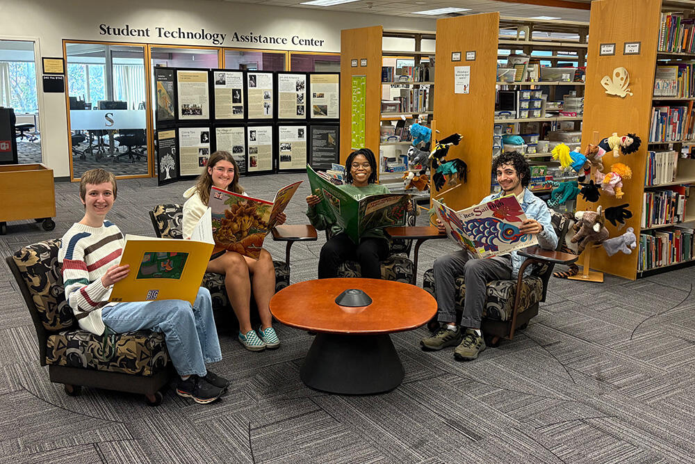 Students reading big books in the University Libraries Educational Resource Center