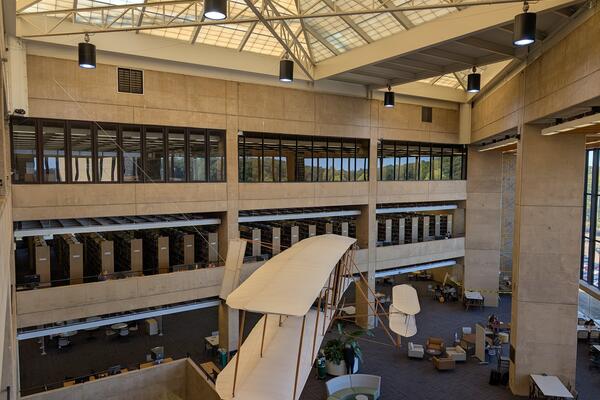A view of the library's atrium showcasing the Wright Flyer replica and the fourth floor with glass enclosures.