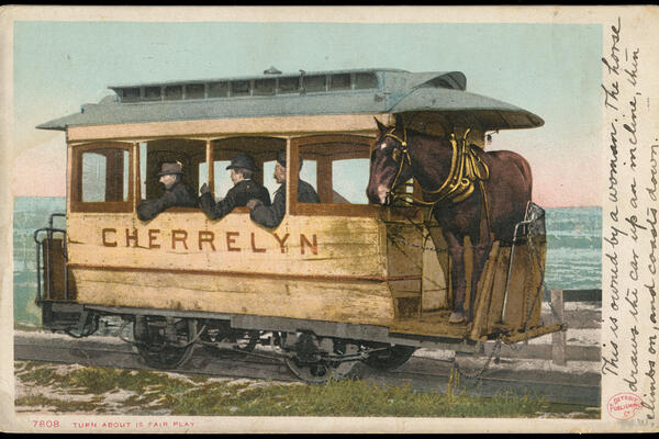 A postcard image of a small train car carrying three men and a horse.