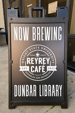 A sign for ReyRey Cafe Now Brewing in Dunbar Library
