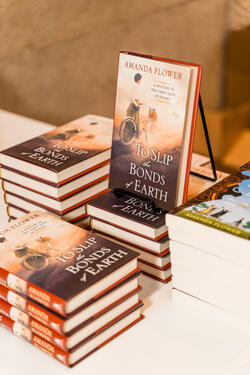 A stack of the book "To Slip the Bonds of the Earth."