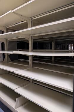 An empty shelving unit with a bowing shelf.