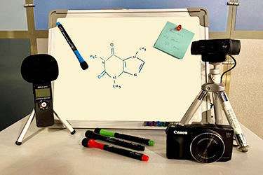 Photo of mini-whiteboard with tripods, cameras, and markers