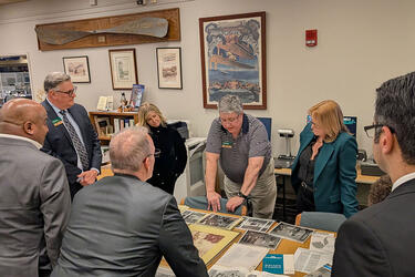 Image of Board of Trustees viewing materials in the Archives during a tour