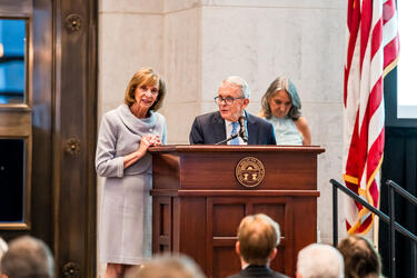 A man and woman speaking at a podium.
