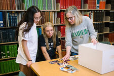 Students collaborating with an archivist in Special Collections and Archives