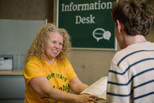 Image of Maggie Perry assisting a student at the Information Desk
